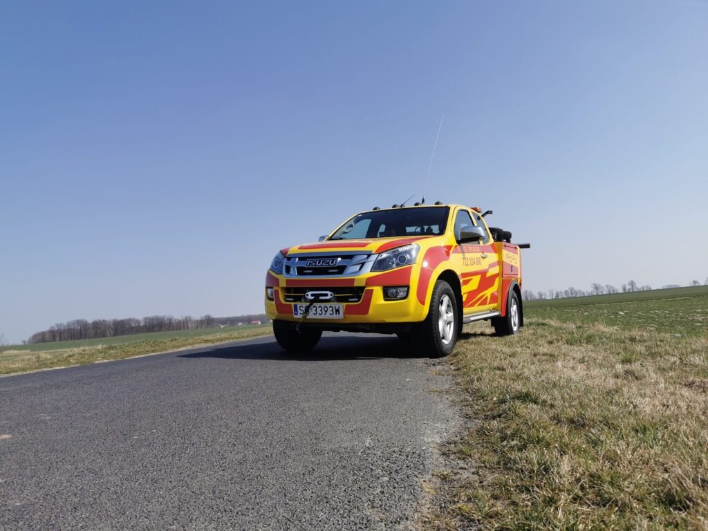 Holowanie TIR Wrocław podczas akcji ratunkowej na drodze, profesjonalny holownik zabezpiecza uszkodzony pojazd ciężarowy.